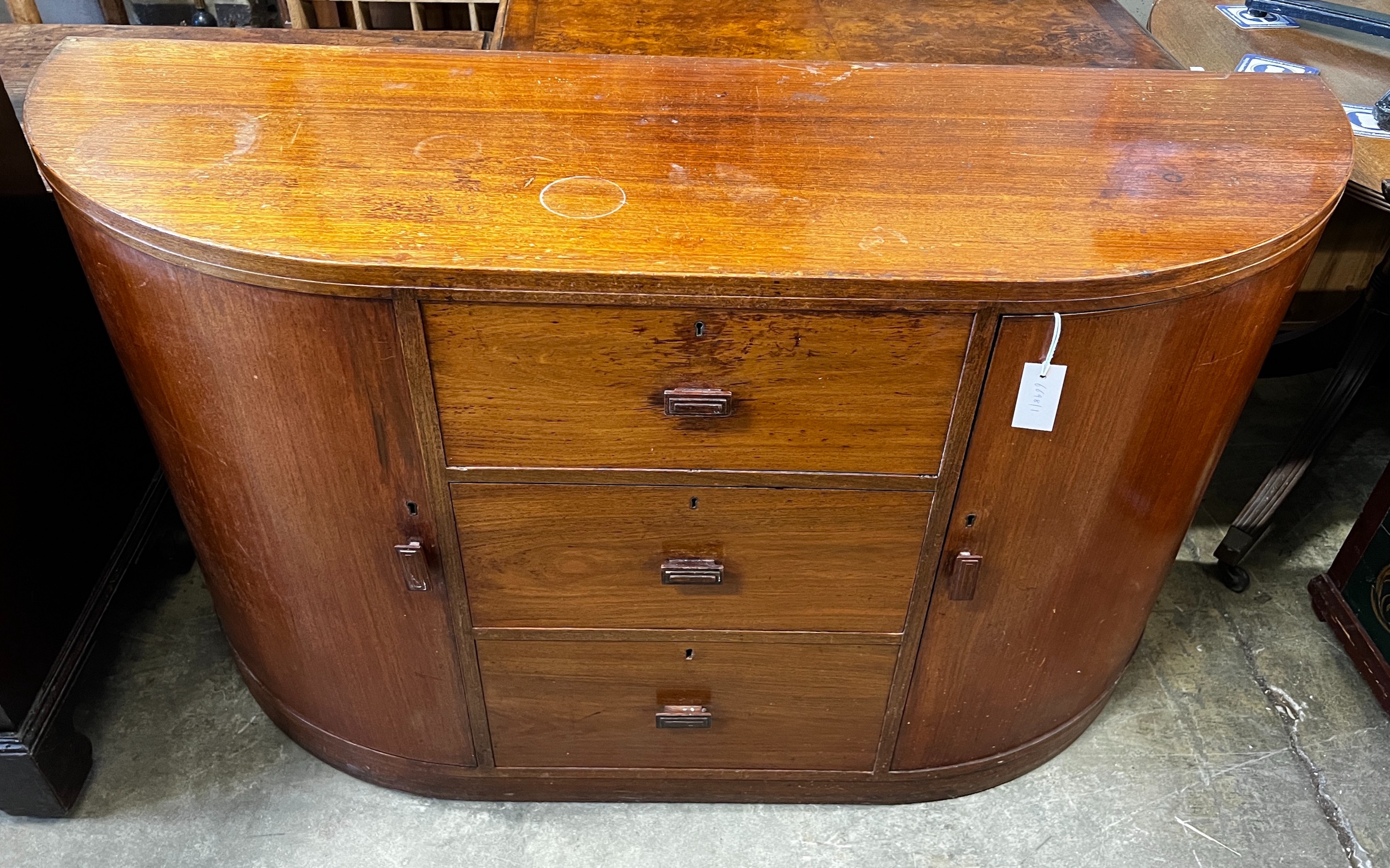 A Betty Joel Token furniture D shaped sideboard, the interior label dated January 1935, width 142cm, depth 46cm, height 82cm